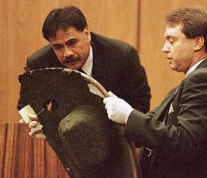 Defense Attorney Clifford Hunt shows witness Detective Steven Guillermo a left front fender for a VW Bug.